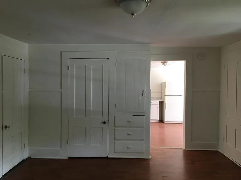 The living room looking into the kitchen. Bathroom on left. Straight ahead is a closet with built-ins next to it.