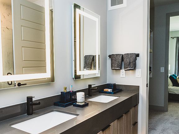 Double-vanity bathroom with backlit mirrors