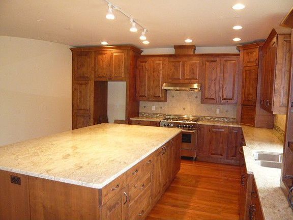 Huge kitchen with large island granite counter-professional stainless steel range with designer hood