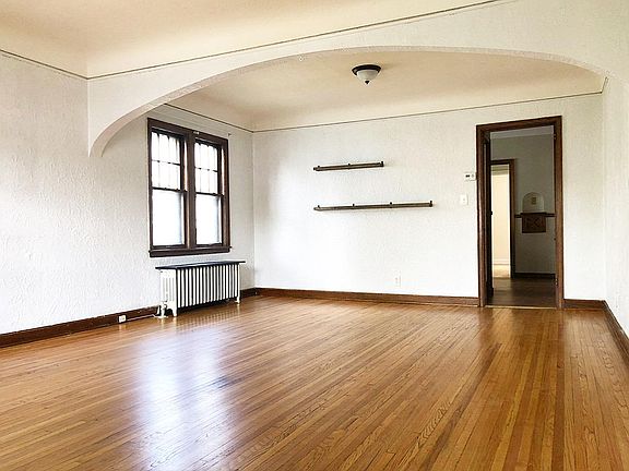 Open floor plan between the living room and dining room, with warm natural wood floors