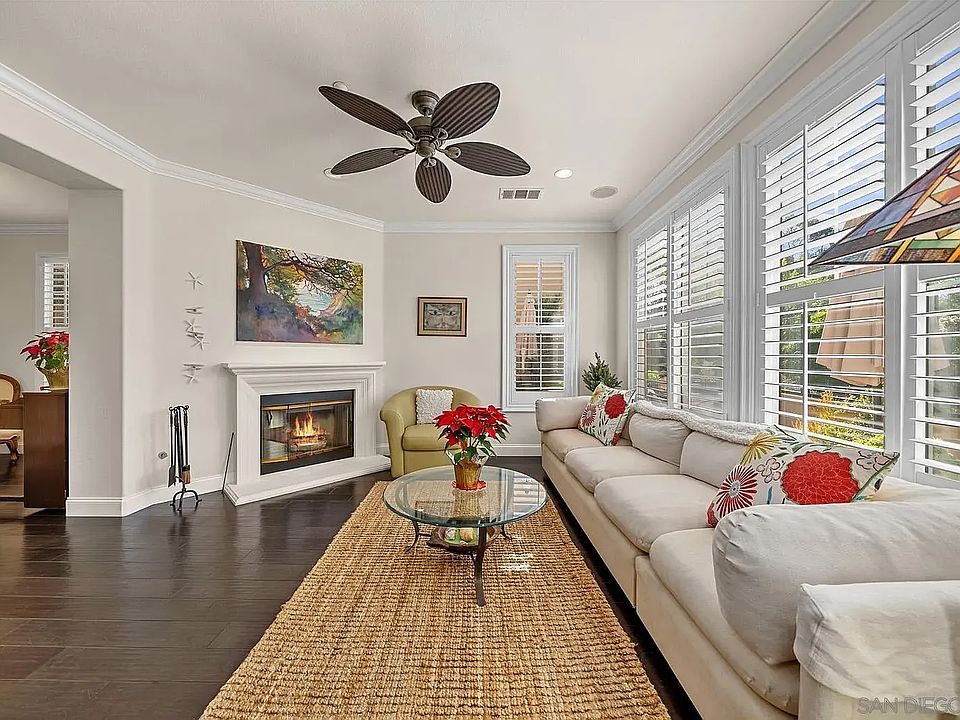 Bright living room, with fireplace, ceiling fans and hardwood floors