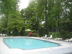 Fenced in pool area with bath house