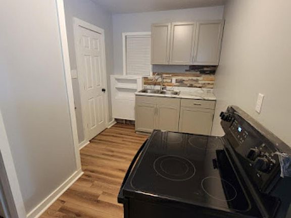 Updated kitchen with modern cabinets, backsplash and electric range.