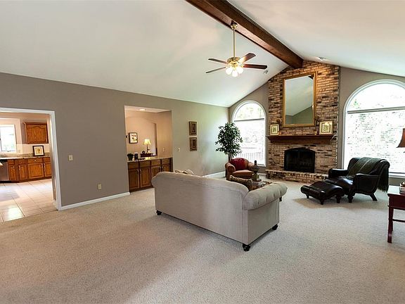 Great room boasts vaulted ceiling, ceiling fan, wood burning fireplace and opens to formal dining room,  kitchen/breakfast room.