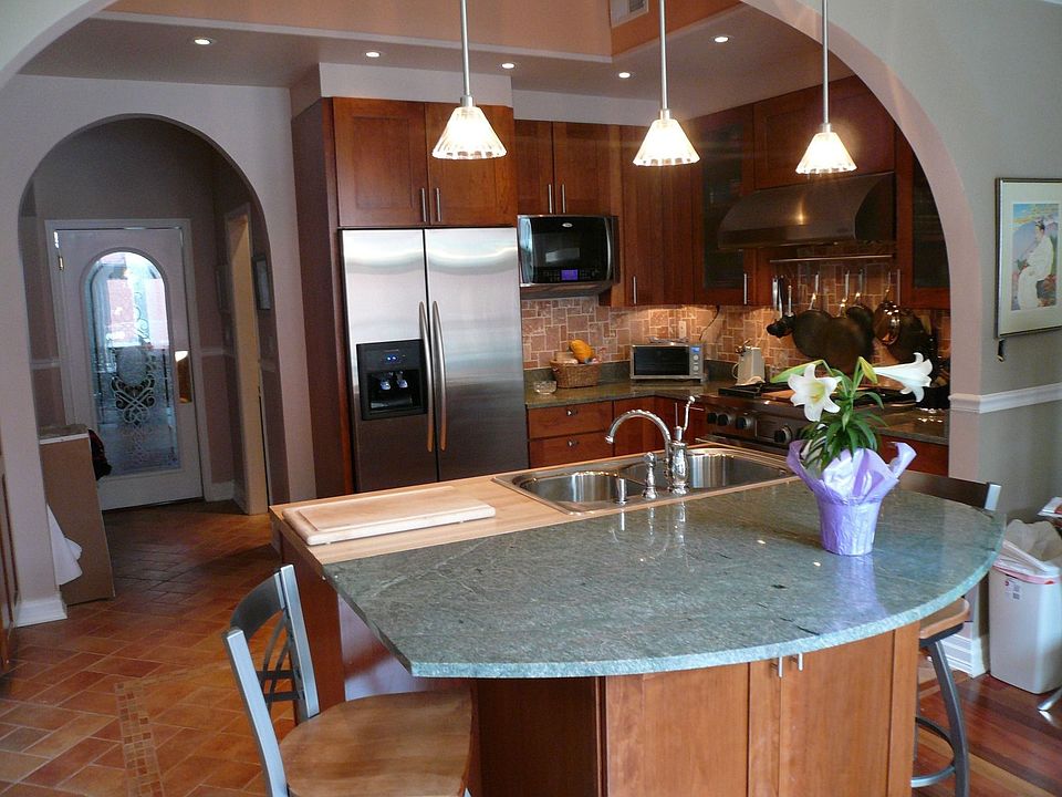 View from fam rm into kitch: granite cntrs, Wolf range, heated ceramic flr