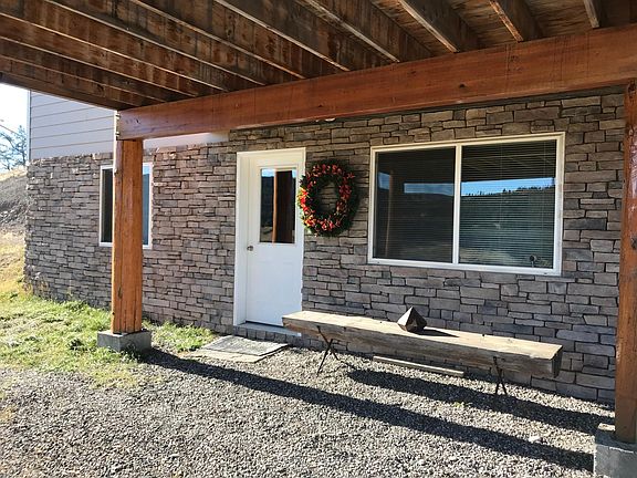 covered private entrance with log bench