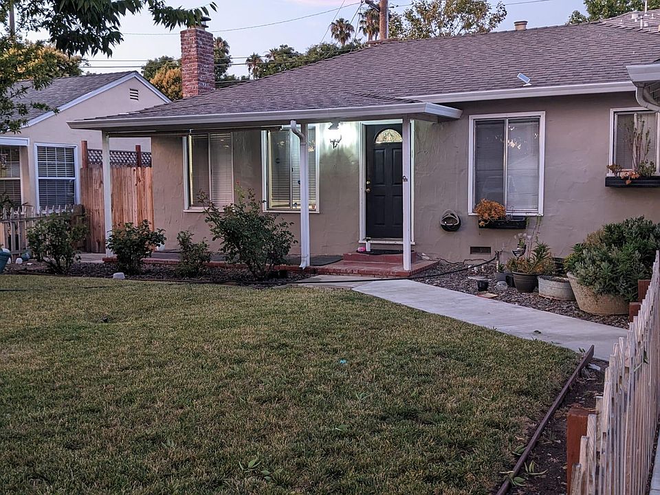 Front yard with green lawn, rose plants and mature fruit trees