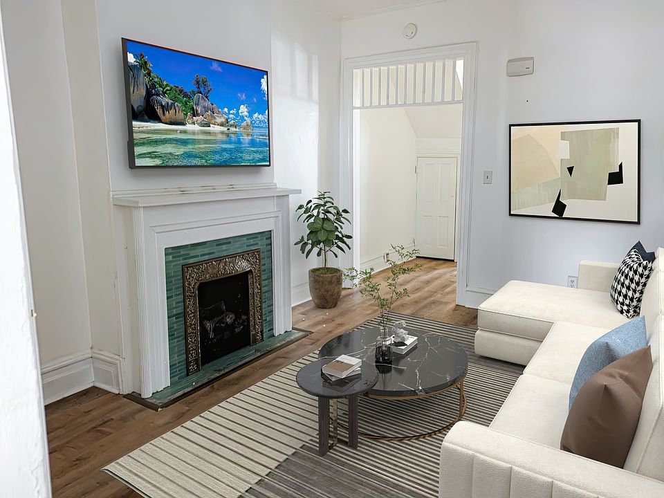 Large living room with high ceiling and gas fireplace.