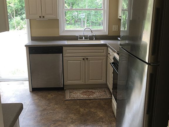 Kitchen features solid wood cabinets and solid surface Corian countertops. 42" upper cabinets to maximize storage space.
