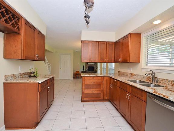 This kitchen has a large window over looking the back yard. This kitchen also features an undermounted stainless steel sink, designer lighting and wine rack.