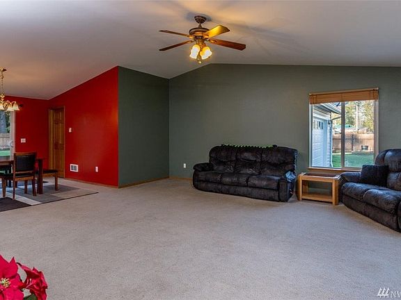 Entering the front door to a spacious, light filled great room, including dining area and lovely six panel wood door to the utility room and garage/ workshop beyond.