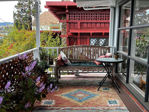 Sitting area with patio table on private front deck, in front of showcase floor-to-ceiling windows
