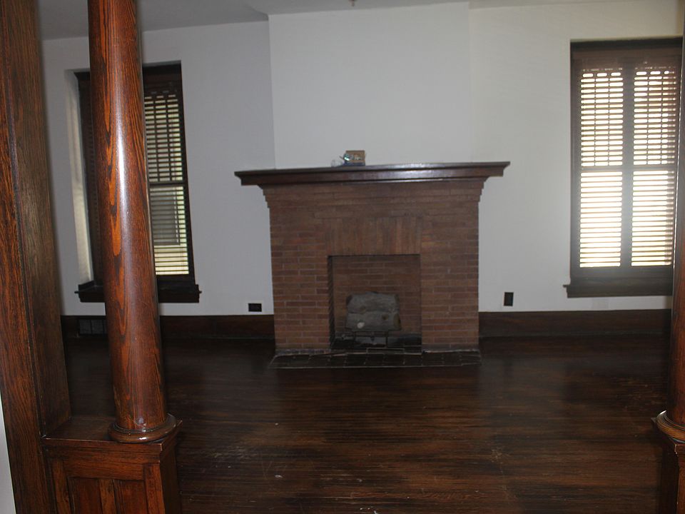 Living room with fireplace and large side windows.