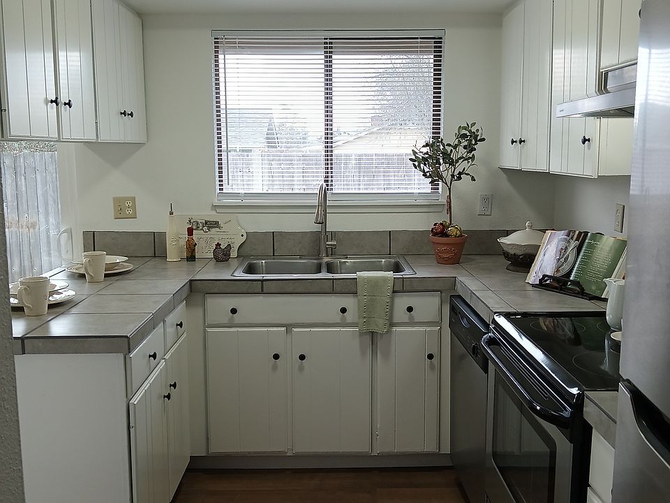 Nicely appointed galley kitchen with pull-down faucet and stainless steel appliances