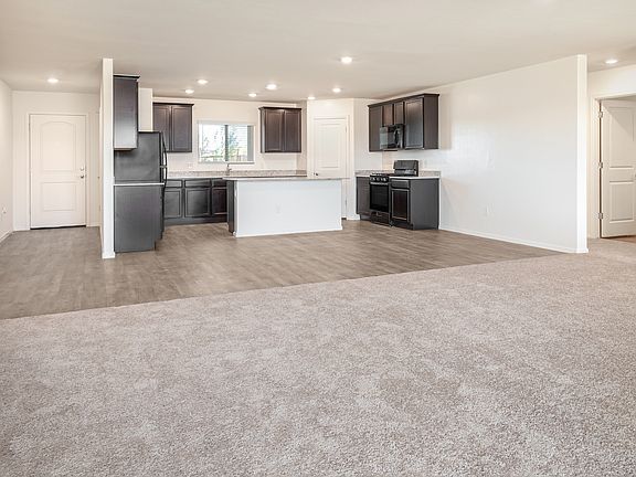 Open-concept layout with an open kitchen leading into the dining area and large living room.