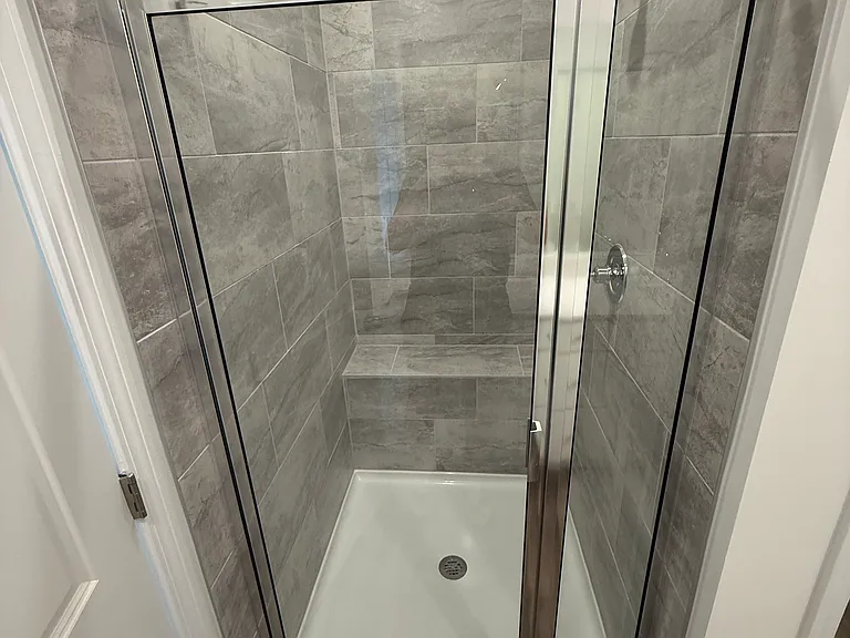 Shower with bench directly in front of double vanity