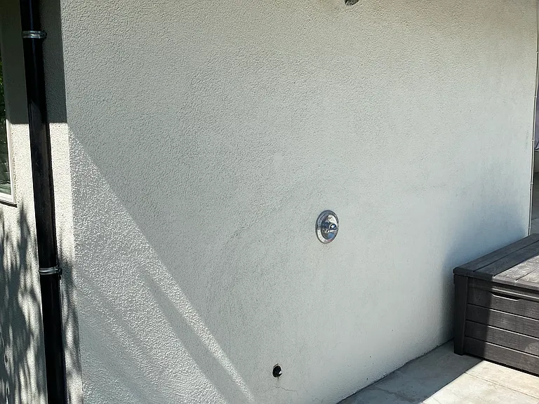 Outdoor shower just adjacent to putting green and spa/jacuzzi