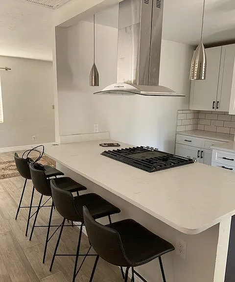 Dining room opened up into kitchen. Beautiful, low maintenance quartz countertops. Gas stove with built-in grill. Lots of lighting options. Counter stools stay!