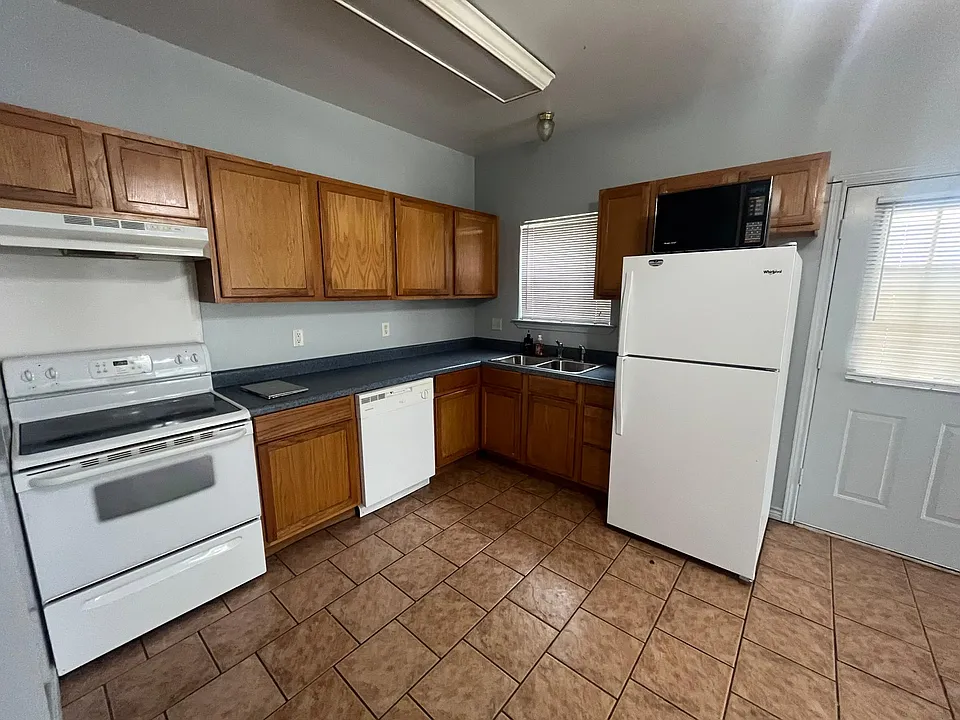 Kitchen with refrigerator and flat top stove included.