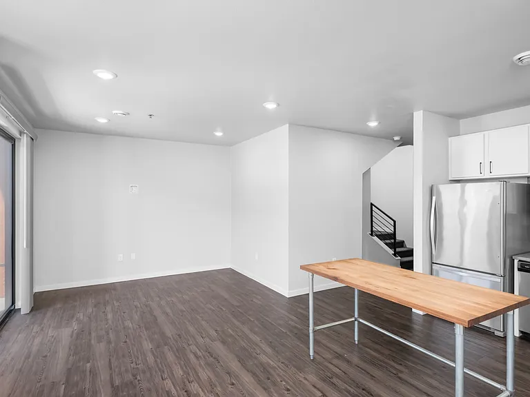 Modern open-concept kitchen and living area with stainless steel appliances, hardwood floors, and ample natural light. Modern open-concept kitchen and living area with stainless steel appliances, hardwood floors, and ample natural light.
