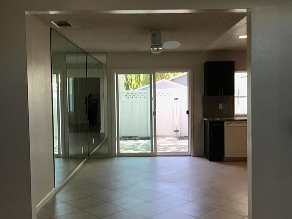 Dining room has tiled floor, ceiling fans and sliding door to backyard