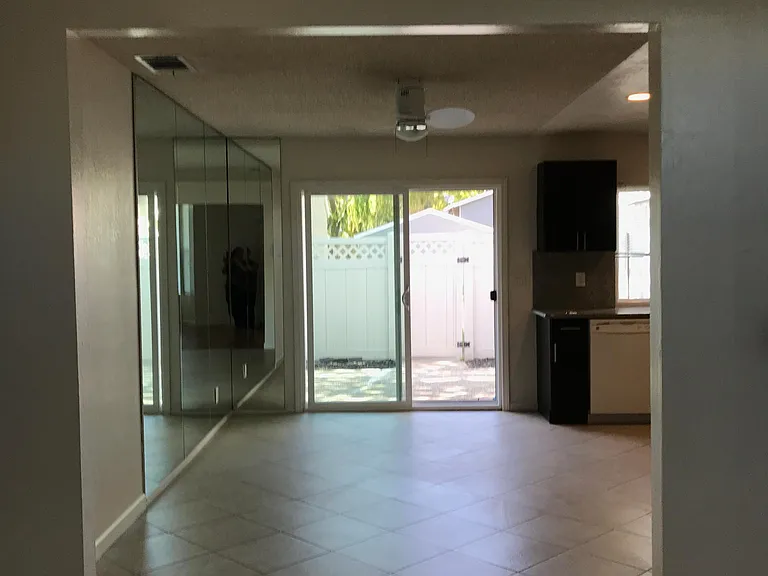 Dining room has tiled floor, ceiling fans and sliding door to backyard