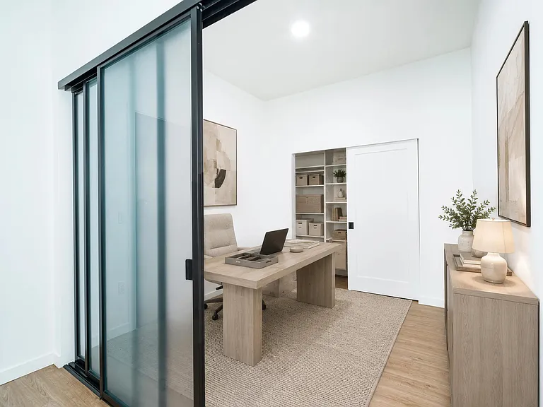 Flexible home office with a sliding glass partition, built-in shelving, and a clean layout that supports focus and everyday productivity.