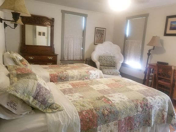 Spacious bedroom with two twin beds. Desk, closet, and dresser.