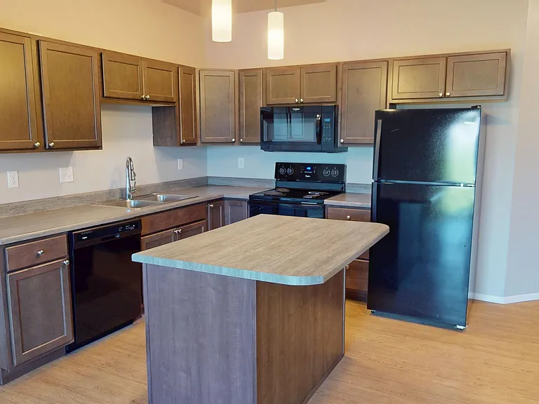 The Highland is a townhome feature an open-concept kitchen with a kitchen island, double sink, dishwasher, and range. The Highland is a townhome feature an open-concept kitchen with a kitchen island, double sink, dishwasher, and range.