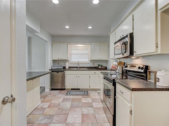 Kitchen has pantry, stainless steel appliances and breakfast bar.