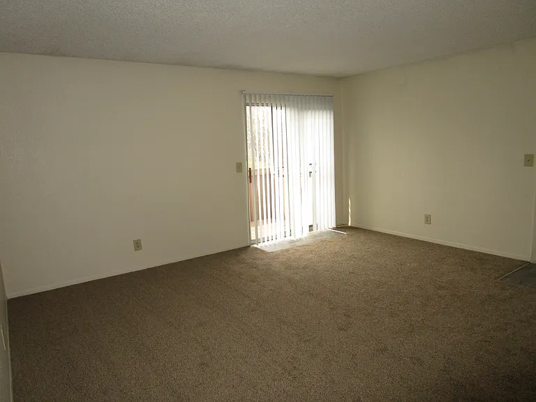 Living room leading sliding glass door to balcony/patio area
