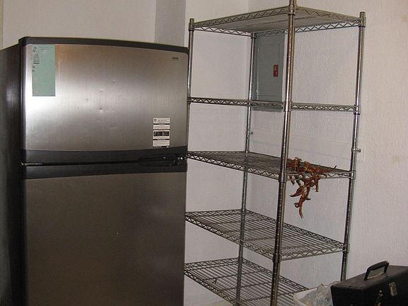 SS fridge + wire shelving rack. New tile floor. Stainless steel 5 burner gas stove.