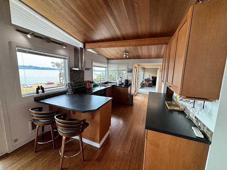 Kitchen with breakfast bar and stools, wineglass rack and full selection of kitchen tools, etc.
