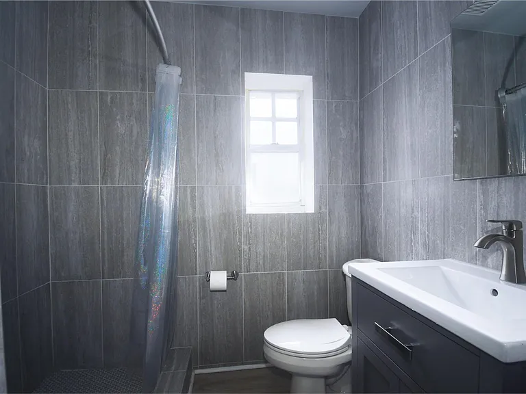 The ensuite bathroom with large format gray tile.