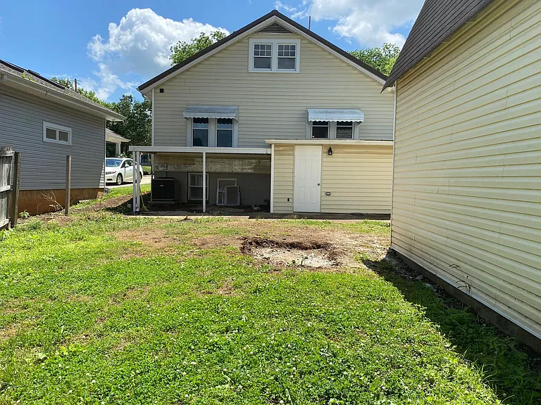 Huge private fenced backyard. Pet friendly. Covered porch and back entrance to first workshop with workbench and storage shelves. At the right of this picture is the HUGE "barn style" workshop with workbench.