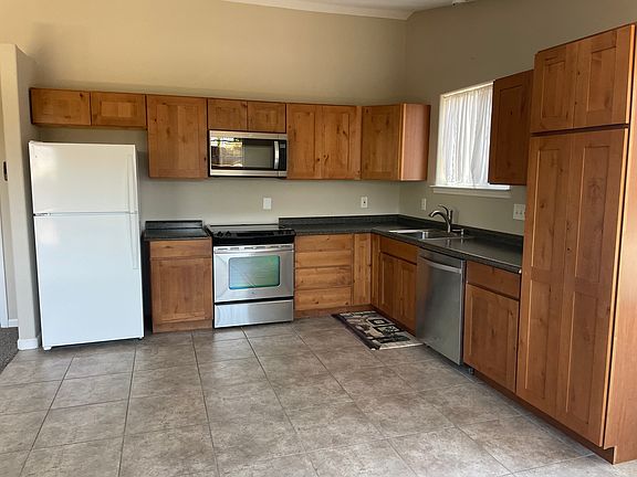 large kitchen with fridge, microwave, range, dishwasher