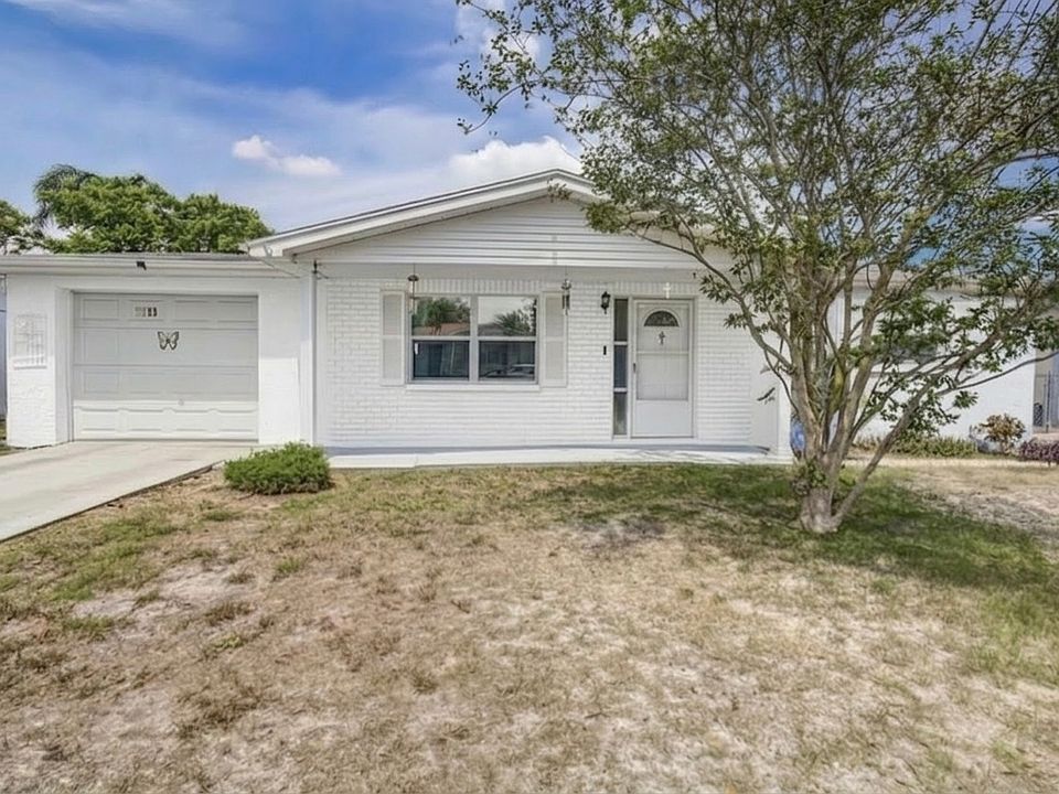 Front exterior of the home with driveway and yard