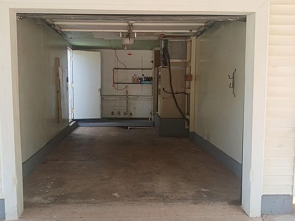 Enclosed garage with back door leading to side of the house attached to the kitchen. Which leads into the backyard. The washer and dryer are hookups are along the back wall, next to the water heater.