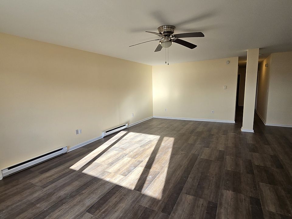 Living room facing rearward. Shows rear hallway, kitchen is to the right