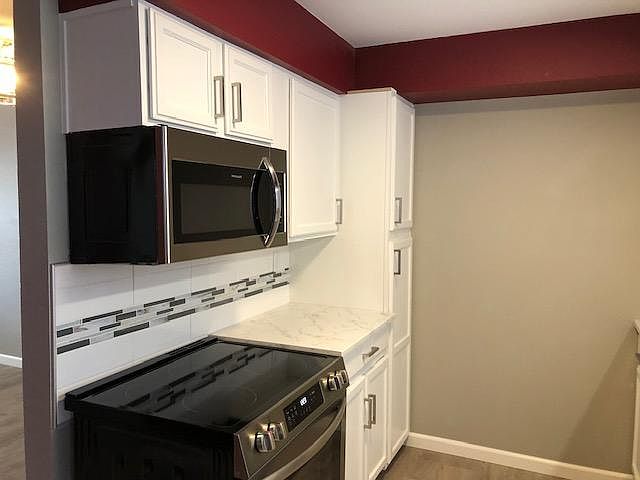 Kitchen view of new Stove and Microwave. Plenty of storage space.