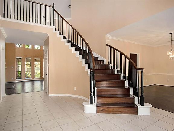 Also in the foyer, is an exquisite curved hardwood staircase, tile floor and direct access to the formal dining room and private study.