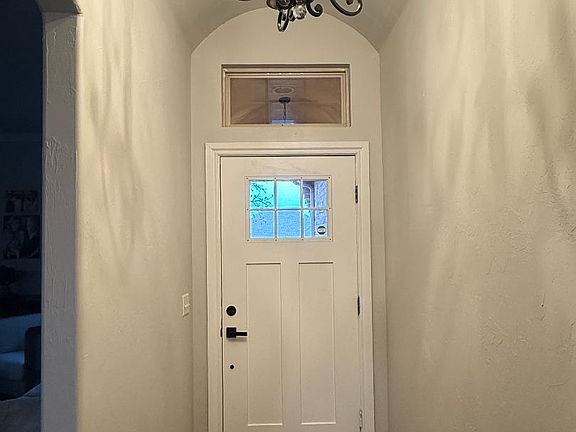 Front entry with vaulted, rounded ceiling, chandelier, & a coat closet.