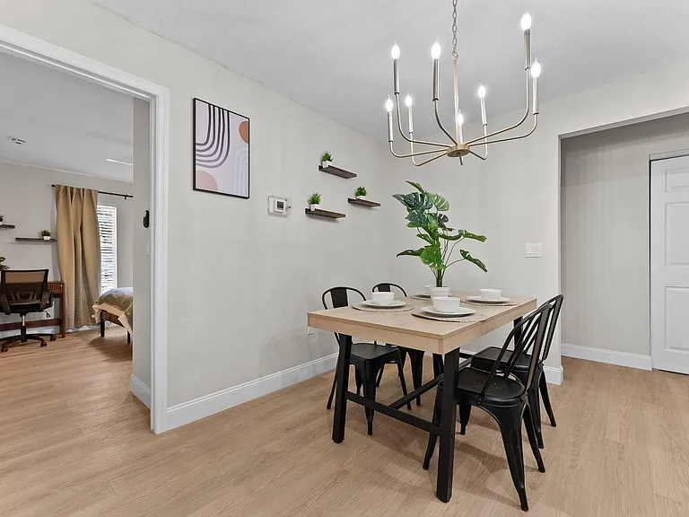 Dedicated dining area with a four-seat table, overhead chandelier, and easy access to adjacent rooms for everyday meals.