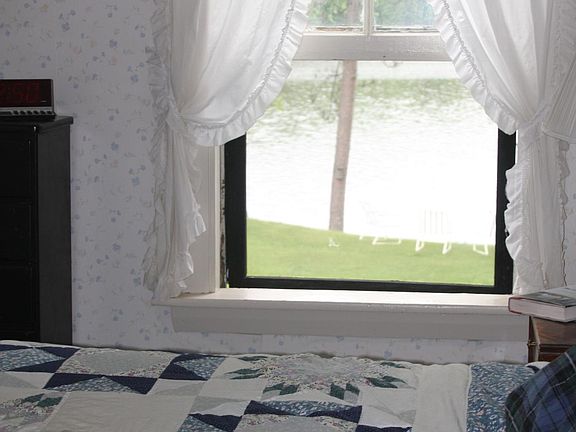 Master bedroom with lake view and double bed.