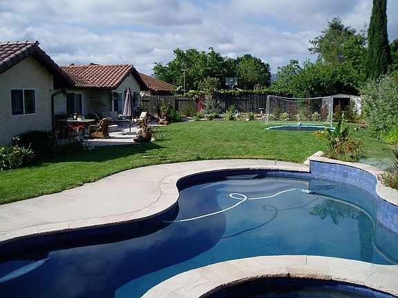 Expansive back yard w/salt water pool/spa,in ground tramp, fruit trees,veg.gar