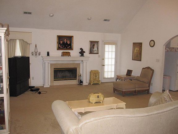 Large open family room with vaulted ceiling and wood burning fireplace.