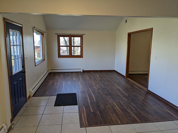 Open, airy dining room room with bay window, new flooring, and vaulted ceiling with fan.