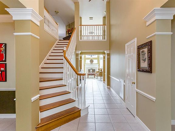 A view from the front entry in to the formal dining room on the left, the study on the right and down the hallway past the stairway to the family room and kitchen. Note the beautiful design elements in this home including the column walls, deep crown