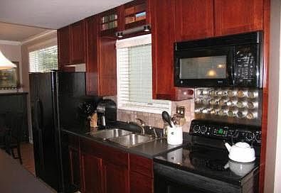 Cherry cabinets accented by sleek black appliances
