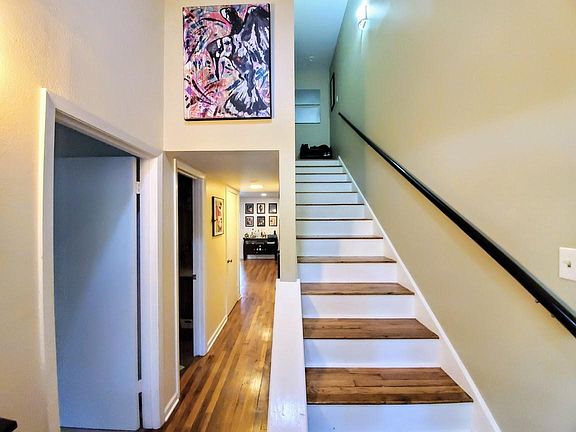 From inside the front door, with stairs leading to the second floor and the master bedroom immediately to the left. The second door off the hallway leads to the master bath.